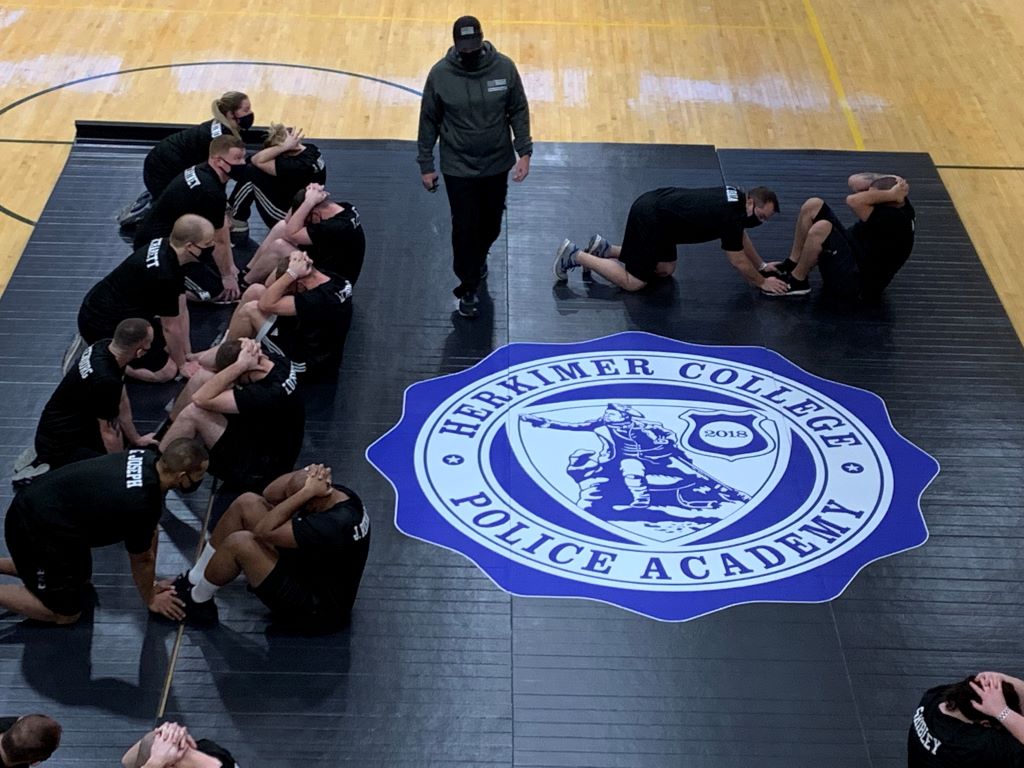 black wrestling mat with police academy logo